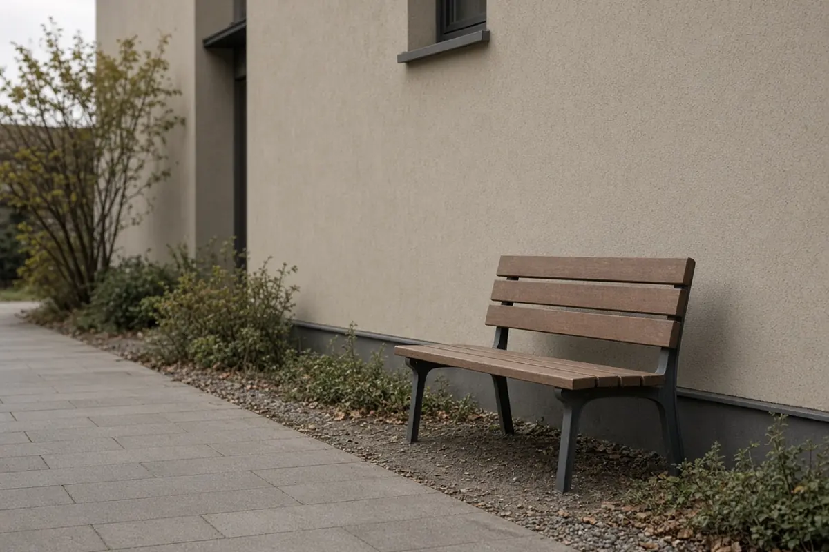 An empty bench on a flat path outside an office, set off the walking line